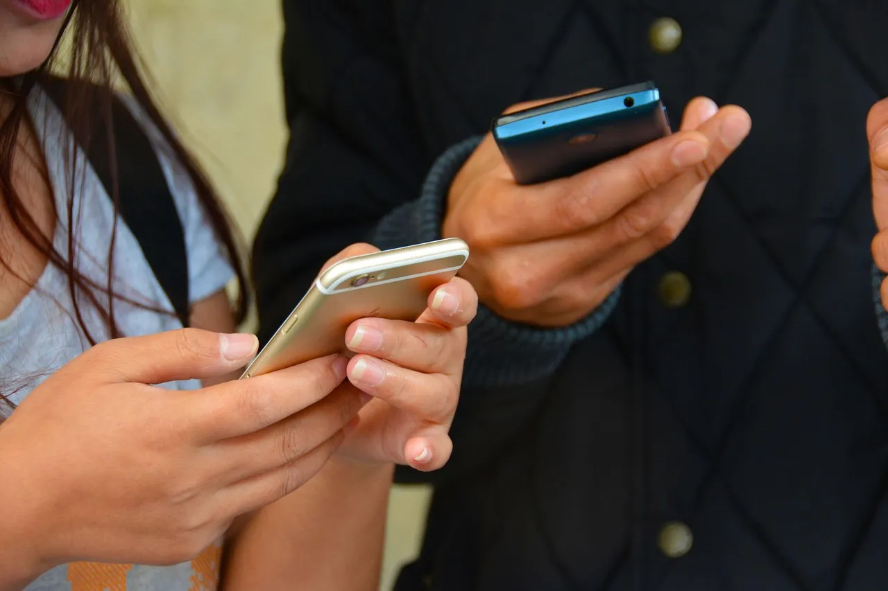 téléphone dans la main de deux personnes 